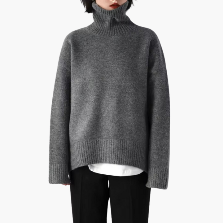 Damebluse med lange ærmer, høj hals og ribbet struktur.