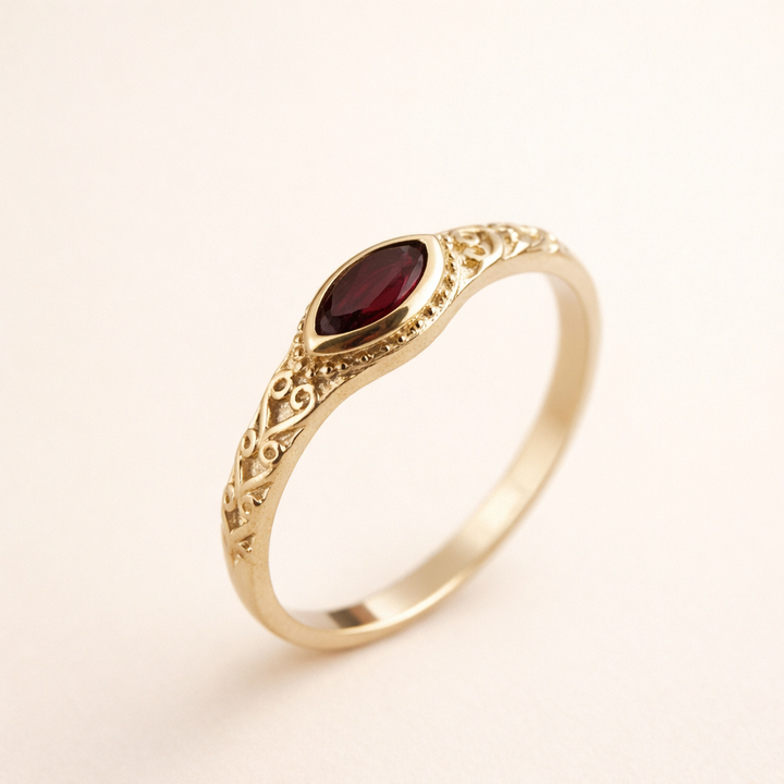 Elegant guldring med en röd zirkonia