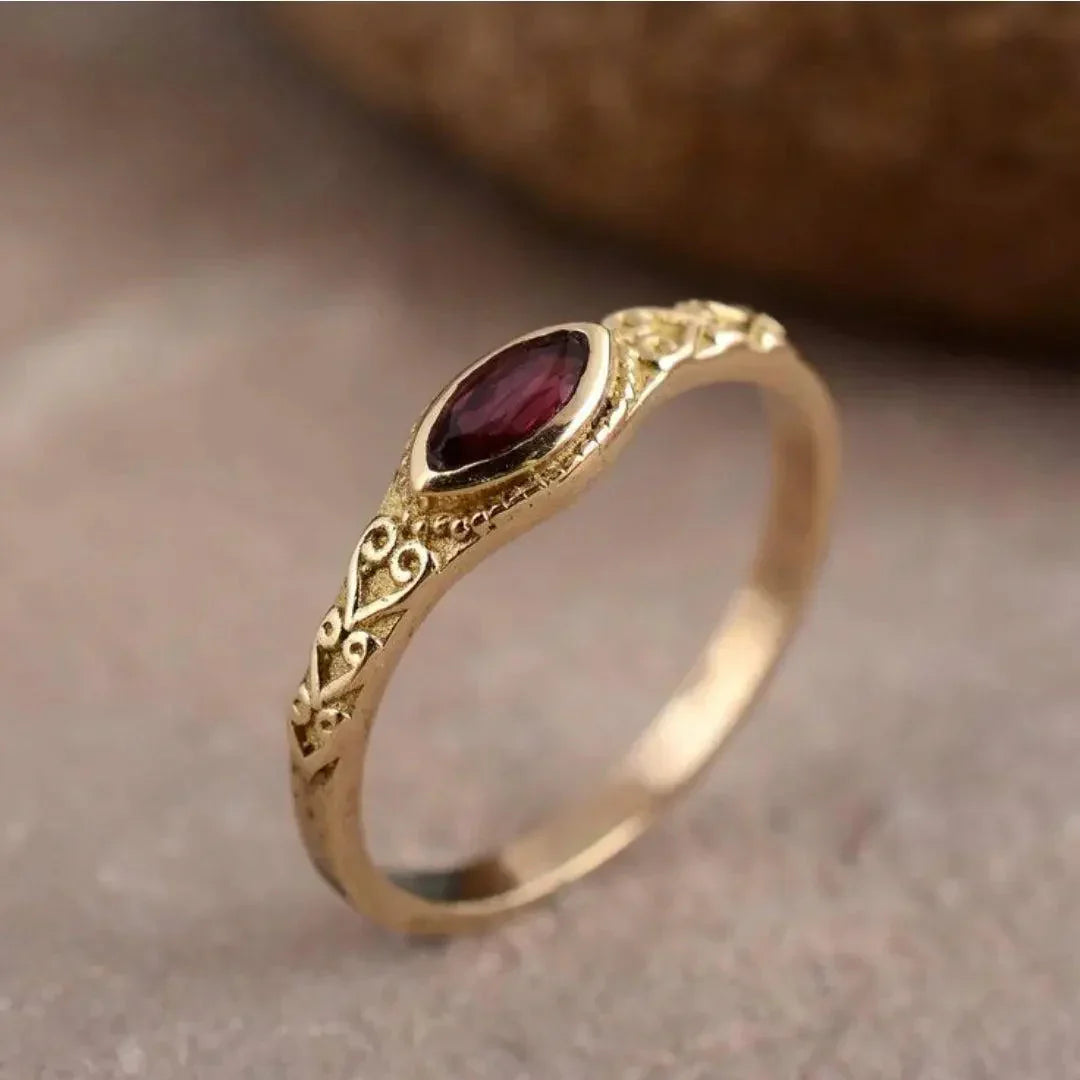 Elegant guldring med en röd zirkonia