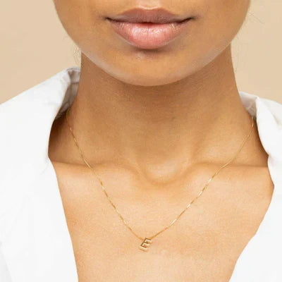 Förfinat halsband i vitguld med initialhänge.